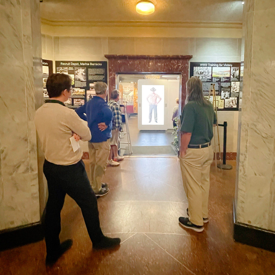Museum visitor approaching the Drill Instructor kiosk in the gallery